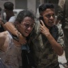 Palestinians react after carrying the bodies of those killed while trying to reach aid trucks entering northern Gaza through the Zikim crossing with Israel, at Shifa Hospital in Gaza City, Sunday.