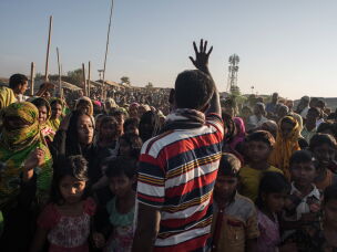 A man gestures telling Rohingya migrants queuing to receive aid that the delivery has been cancelled, at the Kutupalong refugee camp at Cox's Bazar on November 30, 2017.
