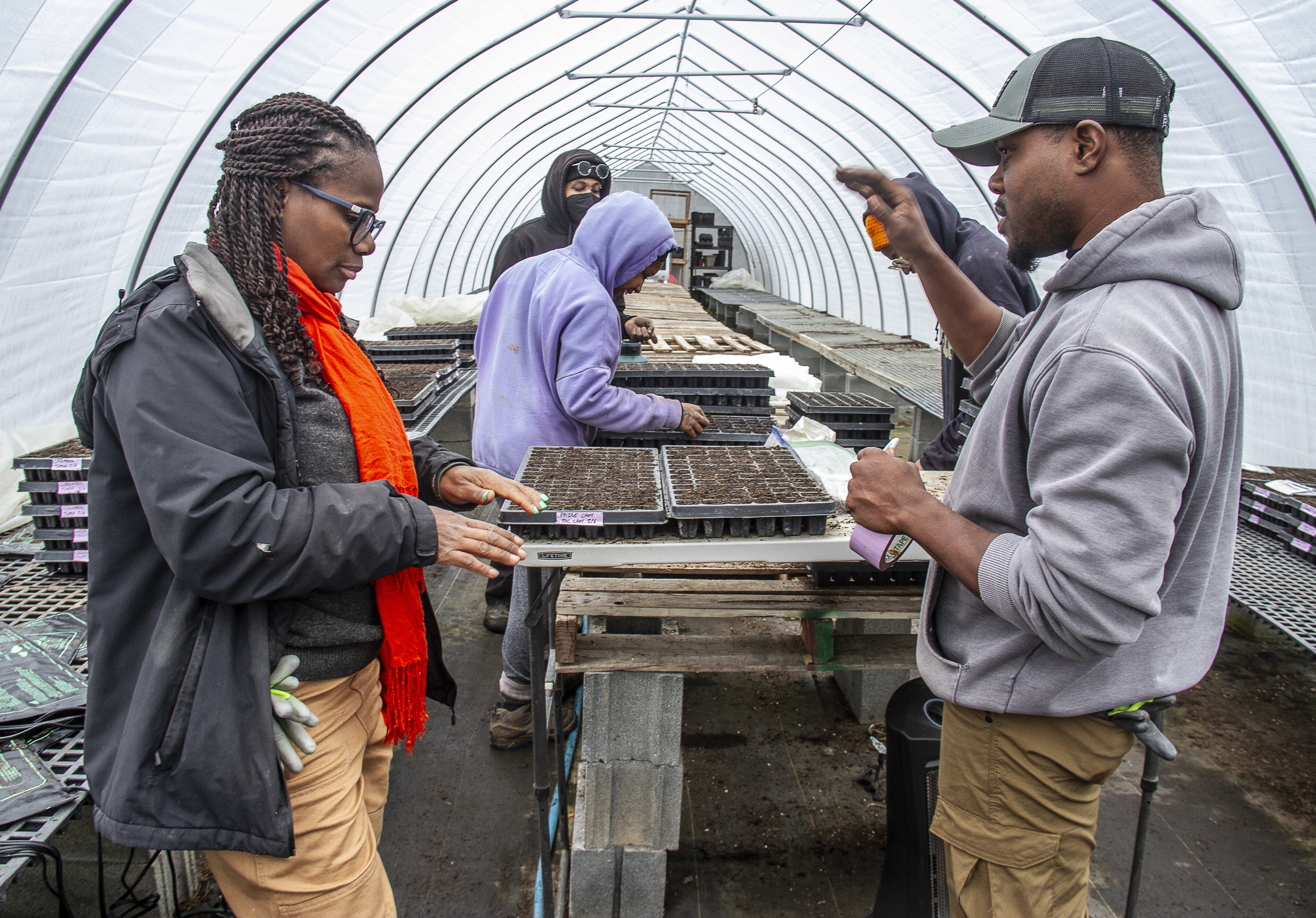 Farmer Gale Livingstone alongside volunteers Sydney Harris, Lewis Taylor, Emmani Phillips-Quigley and Jimi Palmer plant seeds at Deep Roots Farm in Upper Marlboro, Md.
