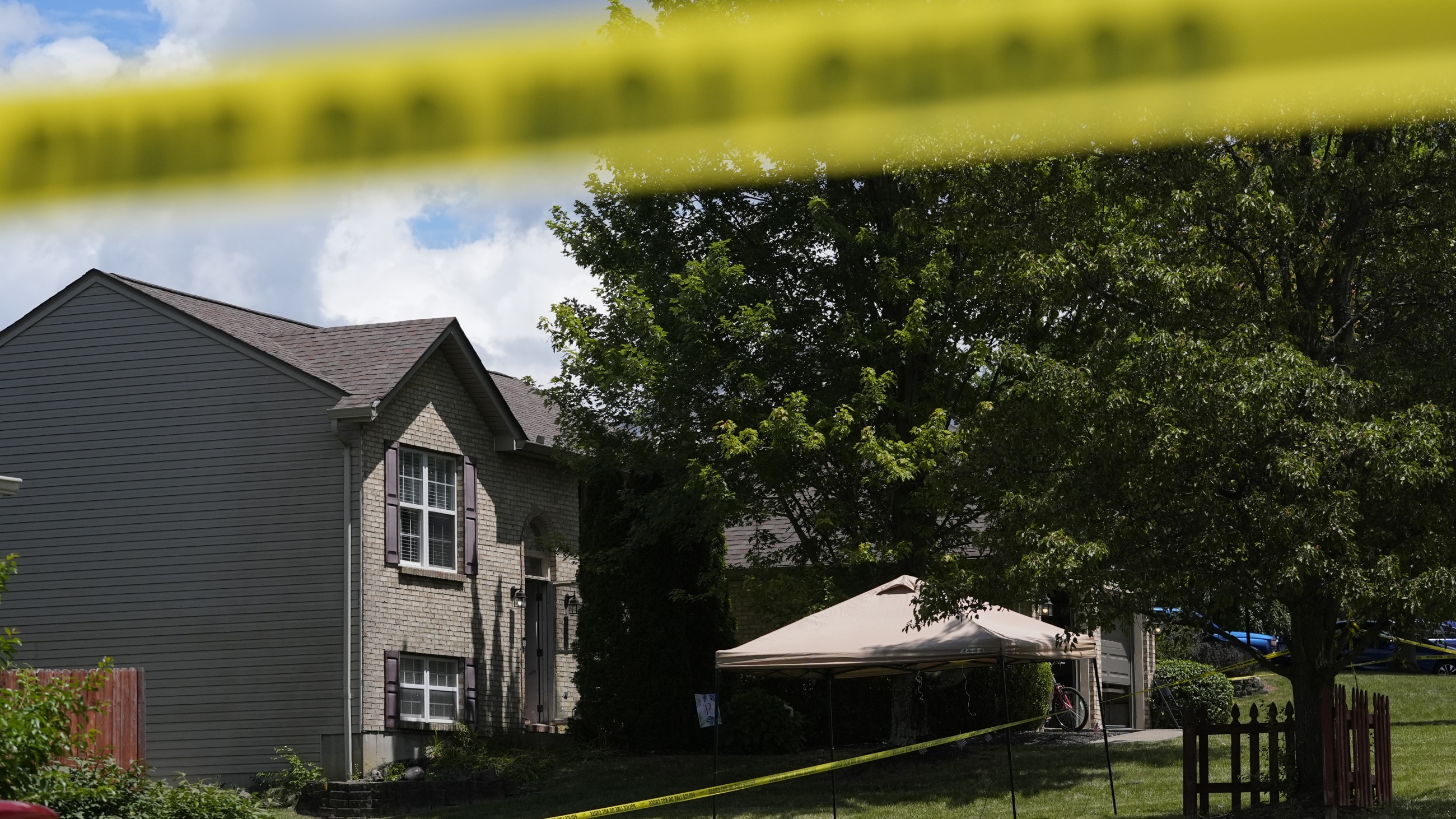 Yellow police tape is seen around the perimeter of a home where a shooting took place on Saturday in Florence, Ky. Police say several people were killed and others wounded in an early morning shooting during a party at this home in northern Kentucky. Police say the shooting suspect later died after fleeing the home and leading police on a vehicle pursuit that ended with the suspect's car falling into a ditch. (AP Photo/Carolyn Kaster)