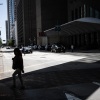 A woman walks in the shade in downtown Houston, Texas in late July 30 during a regional heat wave.