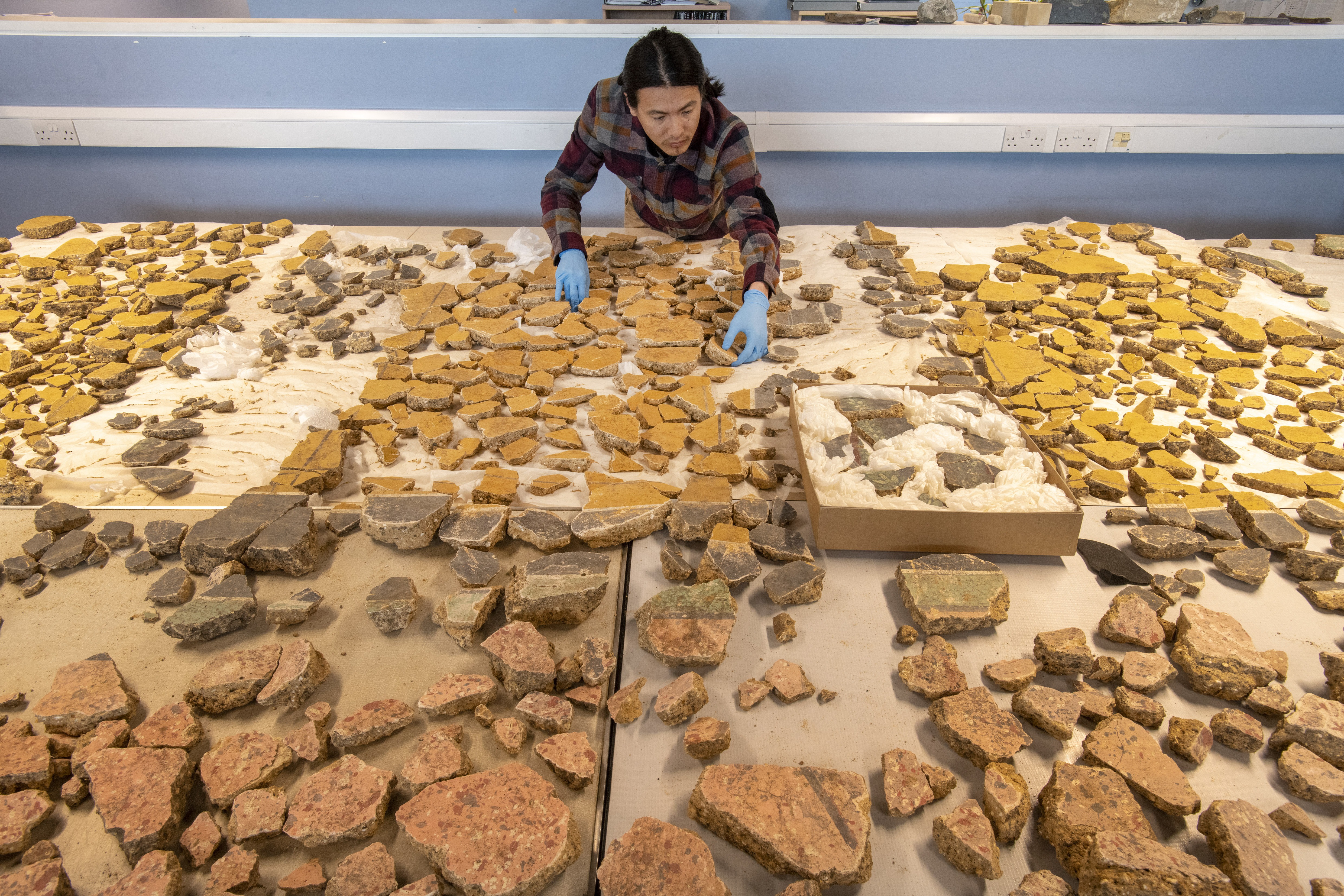Museum of London Archaeology specialist Han Li lays out plaster fragments found in London from a Roman building that was demolished some time before A.D. 200.