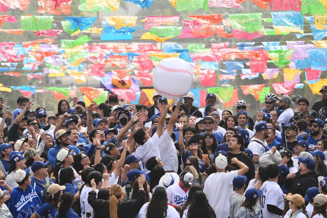 Fans reach for an inflatable baseball during a parade to celebrate the Los Angeles Dodgers baseball team's World Series win on Monday, Nov. 3, 2025, in Los Angeles.