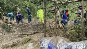 Rescue workers clear mud and debris brought down by a flood in Lang Nu hamlet in Vietnam's Lao Cai province on Tuesday.