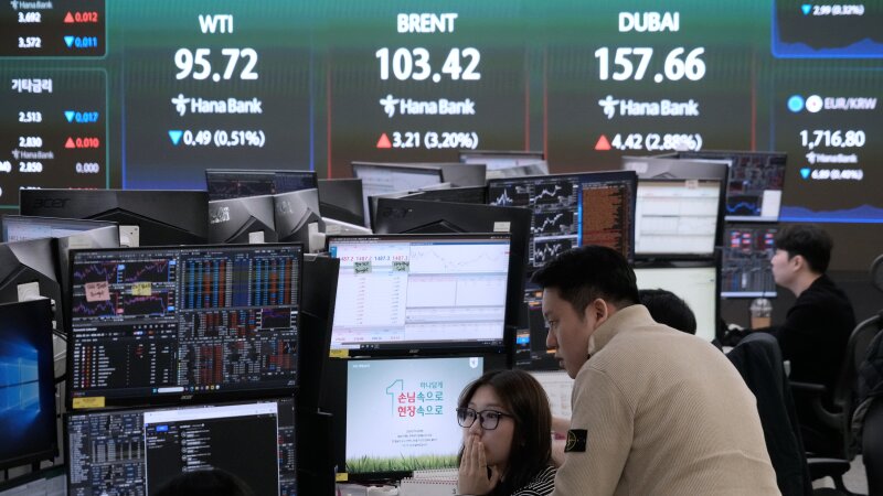 Currency traders watch monitors near a screen showing international oil prices at the foreign exchange dealing room of the Hana Bank headquarters in Seoul, South Korea, on March 18.