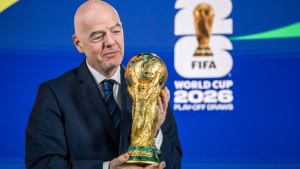 FIFA President Gianni Infantino poses with the World Cup trophy following the 2026 FIFA World Cup European Play-Off draw at the FIFA's Home of Football in Zurich on Nov. 20, 2025.