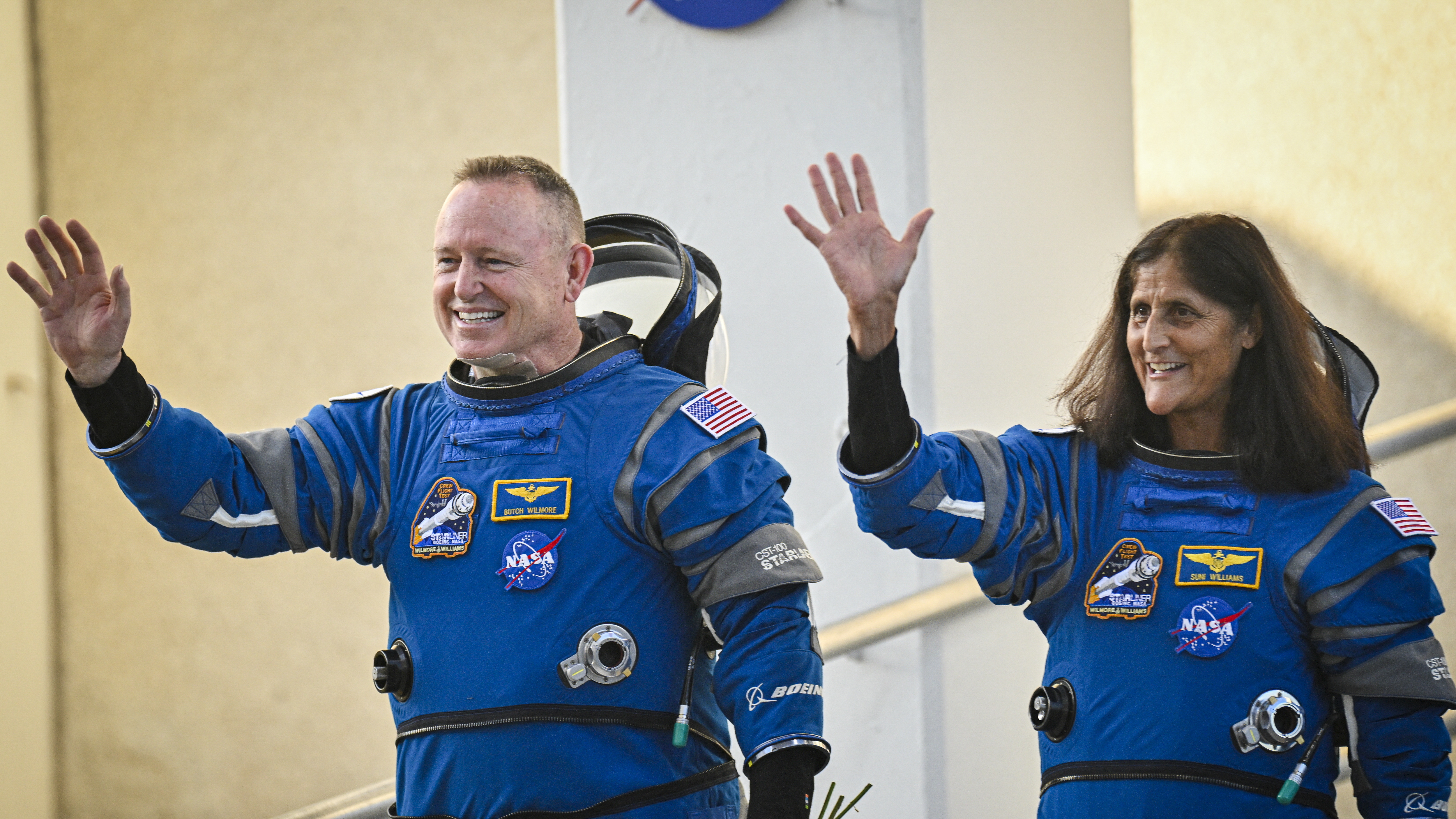 NASA astronauts Butch Wilmore and Suni Williams wave as they prepare to depart the Neil A. Armstrong Operations and Checkout Building at Cape Canaveral Space Force Station in Florida to board the Boeing CST-100 Starliner spacecraft on June 5.