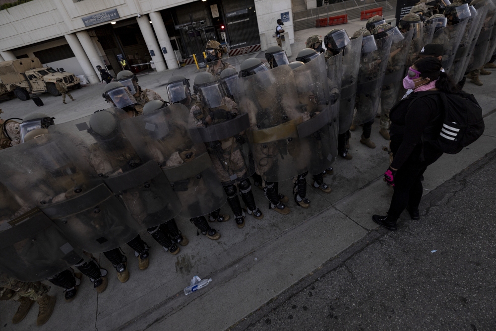 U.S. Marines and National Guard troops patrol the entrance of the Metropolitan Detention Center in Los Angeles as demonstrators gather on July 4, 2025. (AFP via Getty Images)