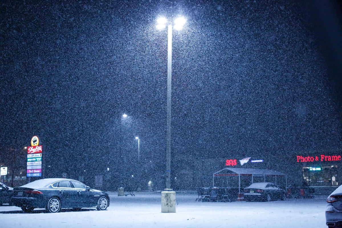 Snow falls on an empty parking lot outside a supermarket in December in Northvale, N.J. Social media weather forecasters span a wide range of reliability — from amateurs with no science background to accredited meteorologists.