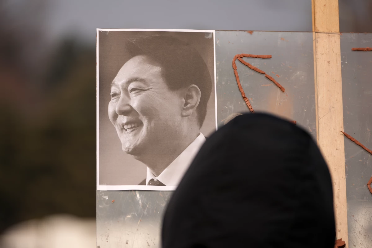 A picture of former South Korean President Yoon Suk Yeol is placed on a board as supporters gather outside Seoul Central District Court, in Seoul, South Korea, Friday, Jan. 16, 2026.