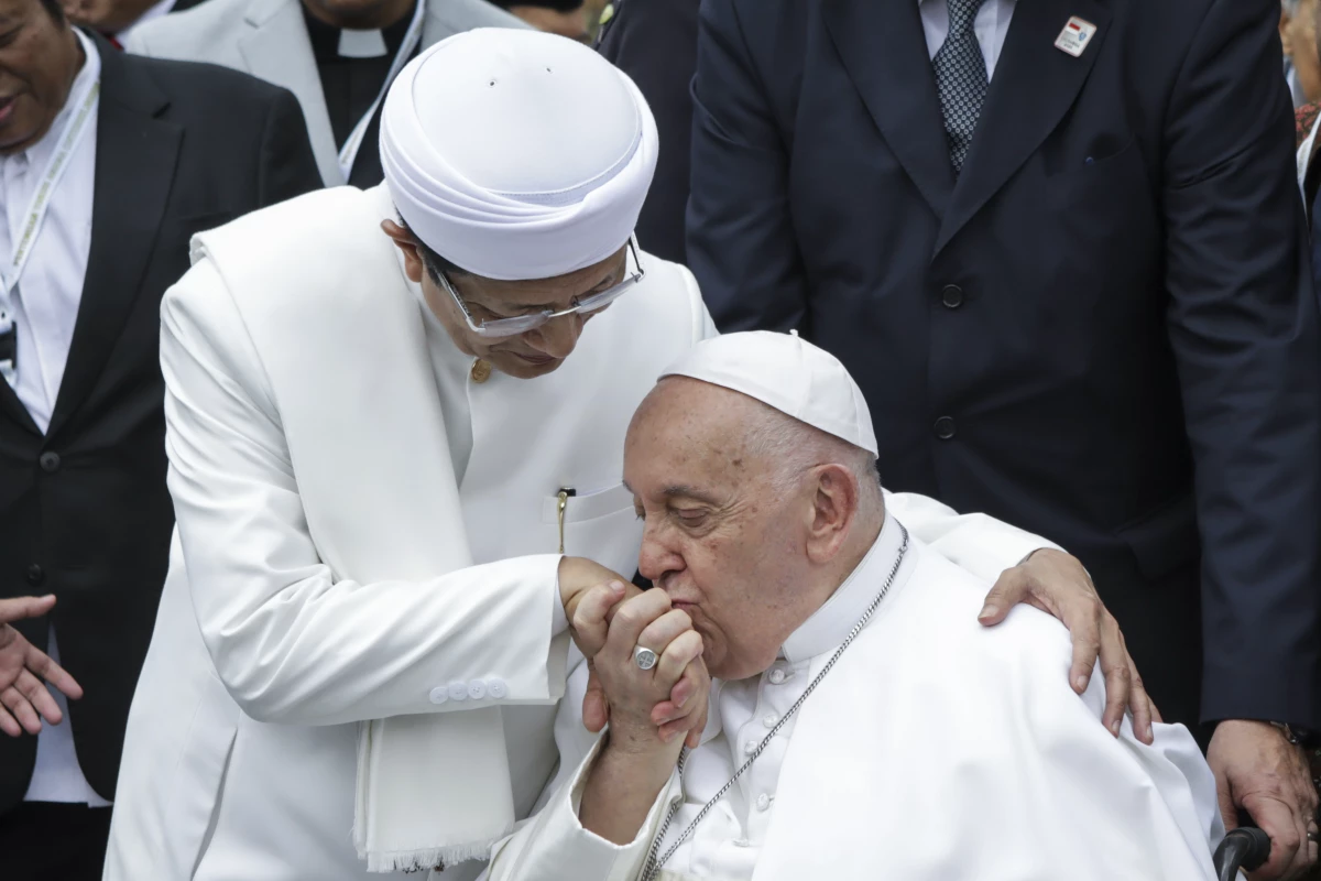 Pope Francis (right) kisses the right hand of the Grand Imam of Istiqlal Mosque Nasaruddin Umar after an interreligious meeting with faith leaders at the Istiqlal Mosque in Jakarta, Thursday.