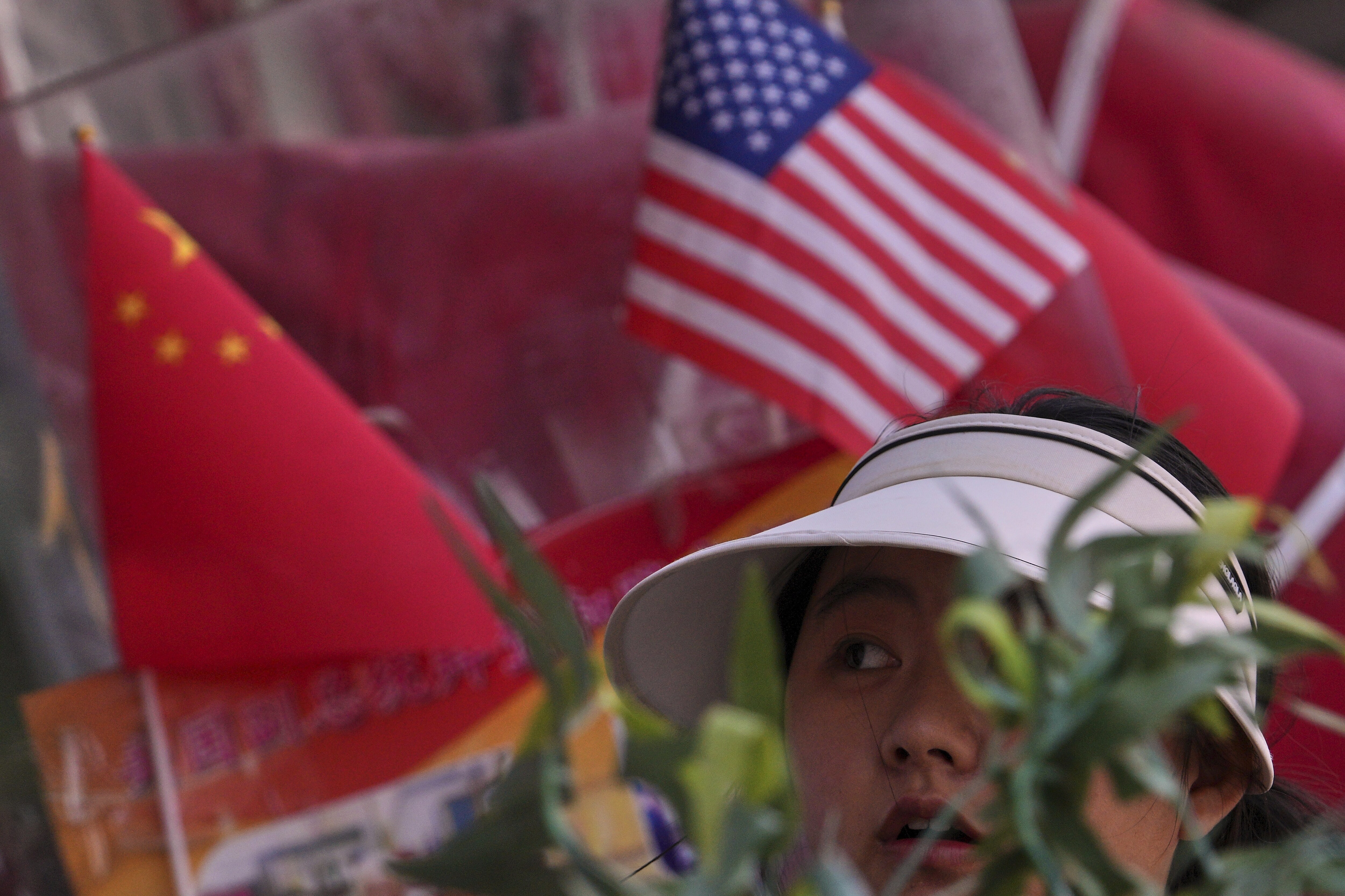 A woman walks past Chinese and U.S. flags on display at a store in Beijing. (AP)