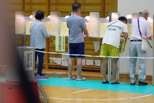 Voters fill in their ballots in the upper house election at a polling station Sunday, July 20, 2025, in Tokyo.