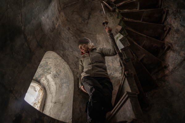 Kristine Tompkins, founder of Tompkins Conservation, inside the San Isidro Lighthouse, which is located at the southern tip of the Brunswick Peninsula in the XII Region of Magallanes and Chilean Antarctica in Chile, with the Darwin Mountain Range in the background and next to a dense native forest. Patagonia, Chile, on Tuesday, November 5, 2024. Tamara Merino for NPR.
