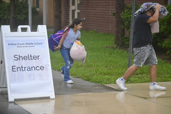 People arrive to shelter at Buffalo Creek Middle School in Bradenton, Fla., on Wednesday ahead of Hurricane Milton's expected landfall.