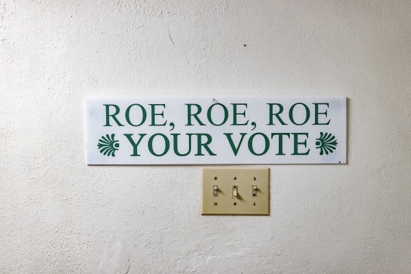 A sign reading "Roe Roe Roe Your Vote" is pictured in an Arizona building before the election.