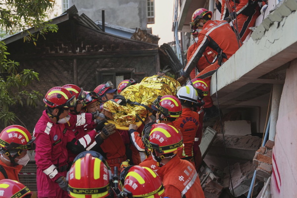 In this photo released by Xinhua News Agency, Chinese rescuers move a survivor out from a collapsed building in the aftermath of an earthquake in Mandalay, Myanmar on Wednesday.