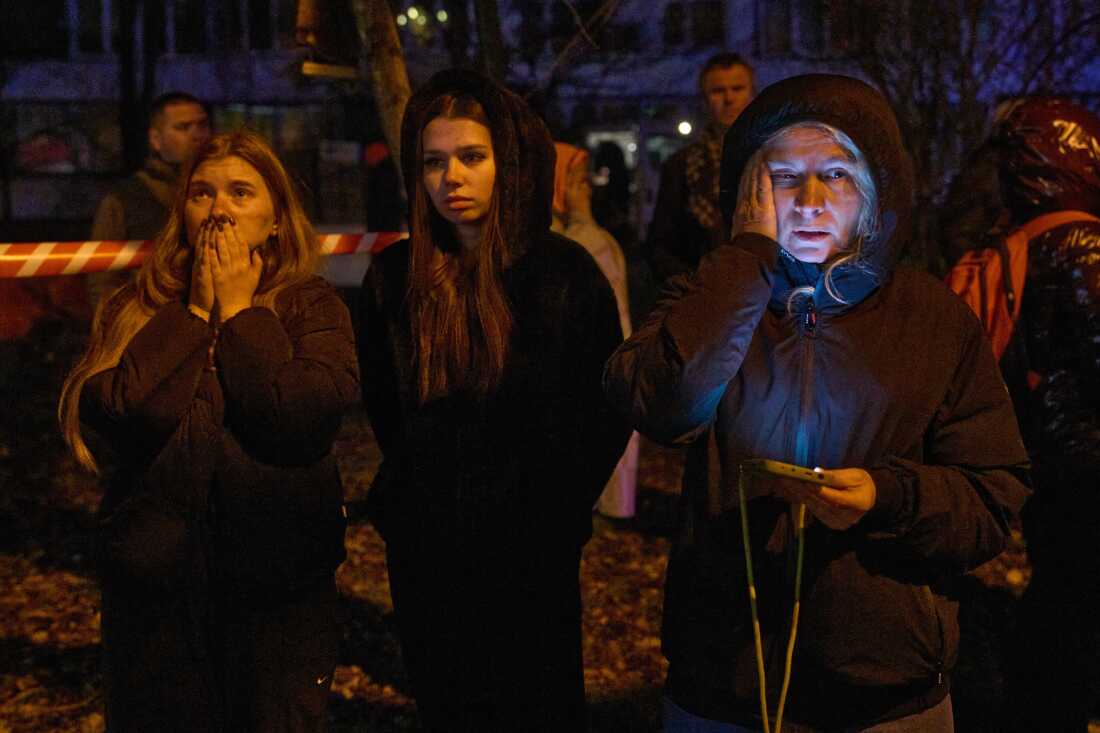 Local residents react as they watch their burning home after a drone hit a multistory residential building during Russia's night drone attack in Kyiv, Ukraine, Tuesday.
