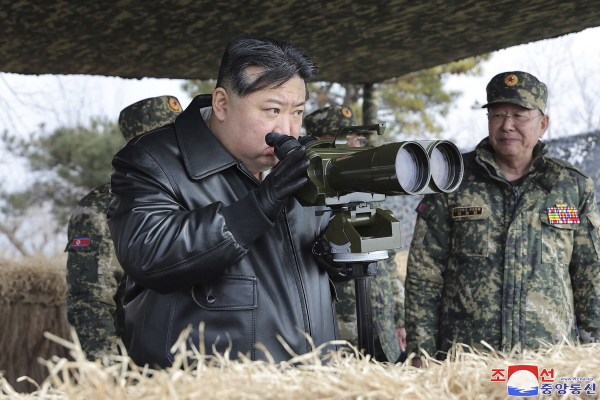 In this image distributed by the North Korean government, North Korean leader Kim Jong Un, left, supervises artillery exercises on March 7, 2024.