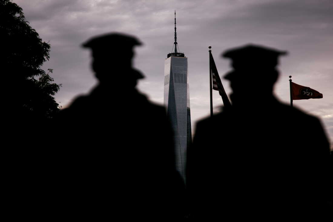 Police stand in Jersey City, N.J., with One World Trade Center visible in the background as they participate in an event on Friday honoring the 25th anniversary