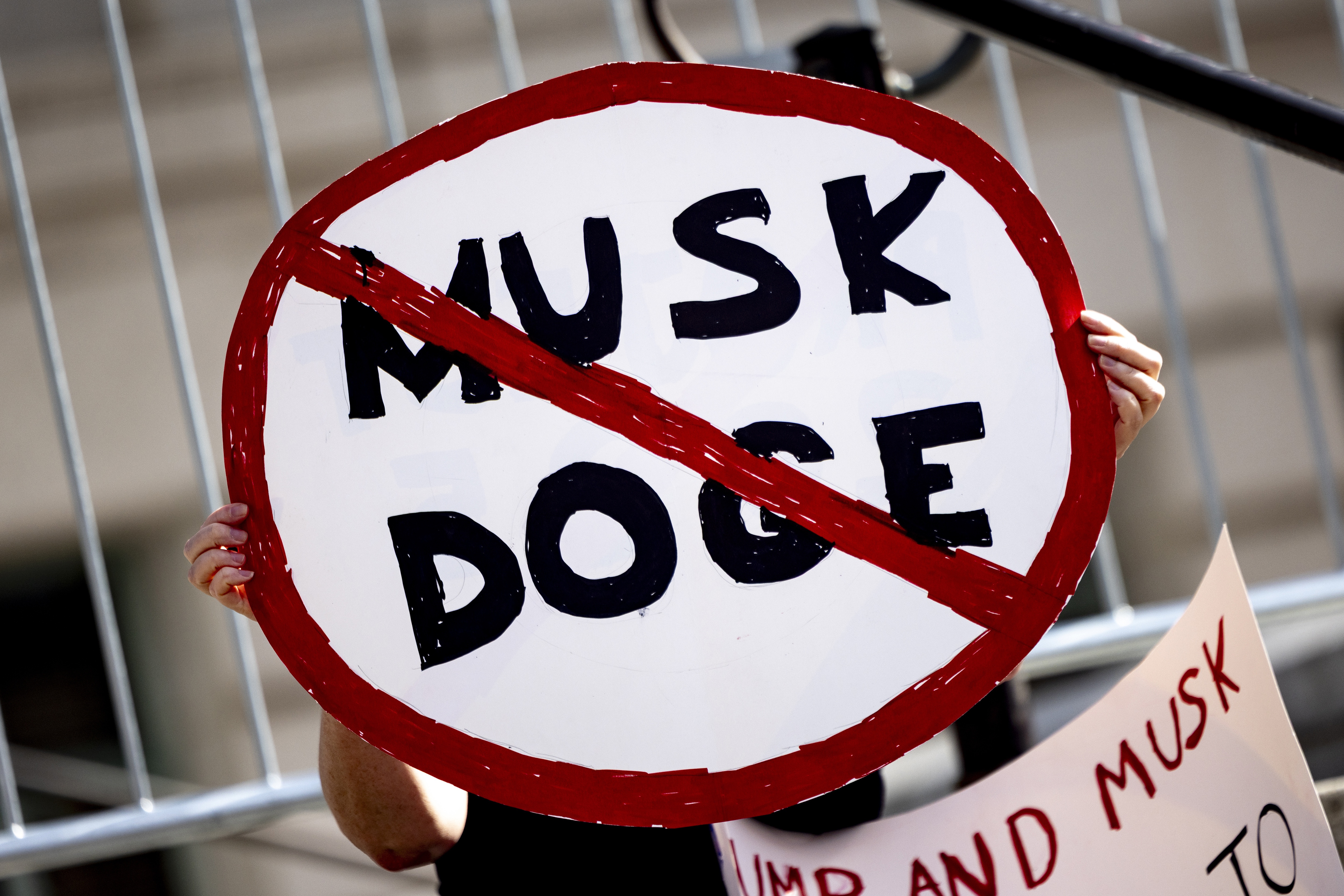 A demonstrator holds a sign during a February rally in Los Angeles to protest President Trump's billionaire adviser Elon Musk and his DOGE team. (AP)