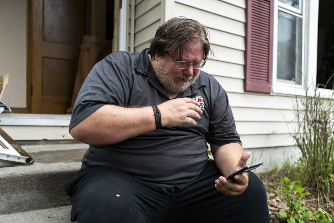 Daniel Carlson reads a text message he received this morning outside his home on June 14, 2025 in Minneapolis, Minnesota. Carlson received a message from Vance Boelter, Carlson's roommate and a suspect in the shooting of two Democratic-Farmer-Labor lawmakers.