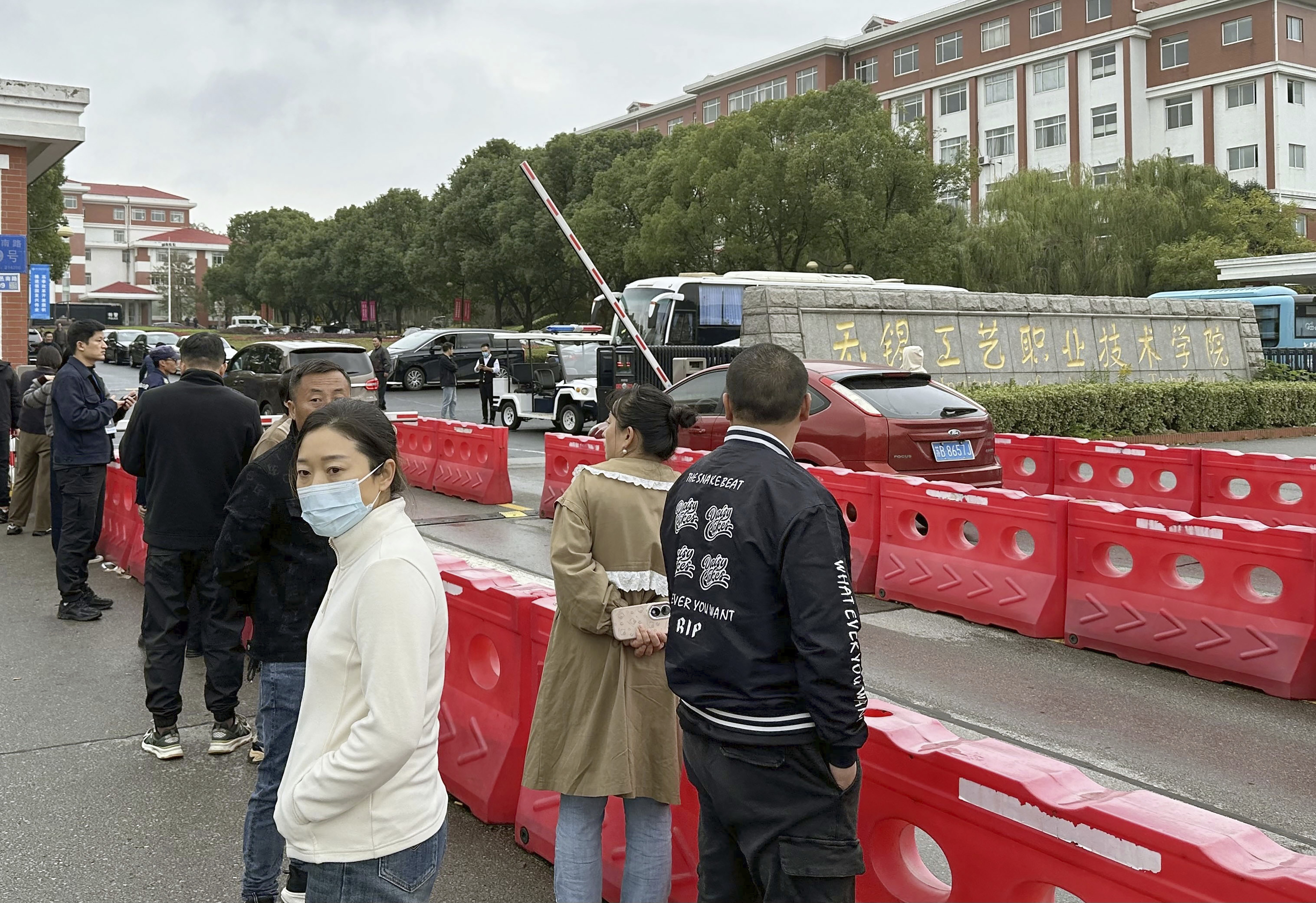 Guardians gather in front of the Wuxi Vocational Institute of Arts and Technology in Yixing, eastern Chinese city of Wuxi on Nov. 17, 2024, a day after a stabbing attack took place.