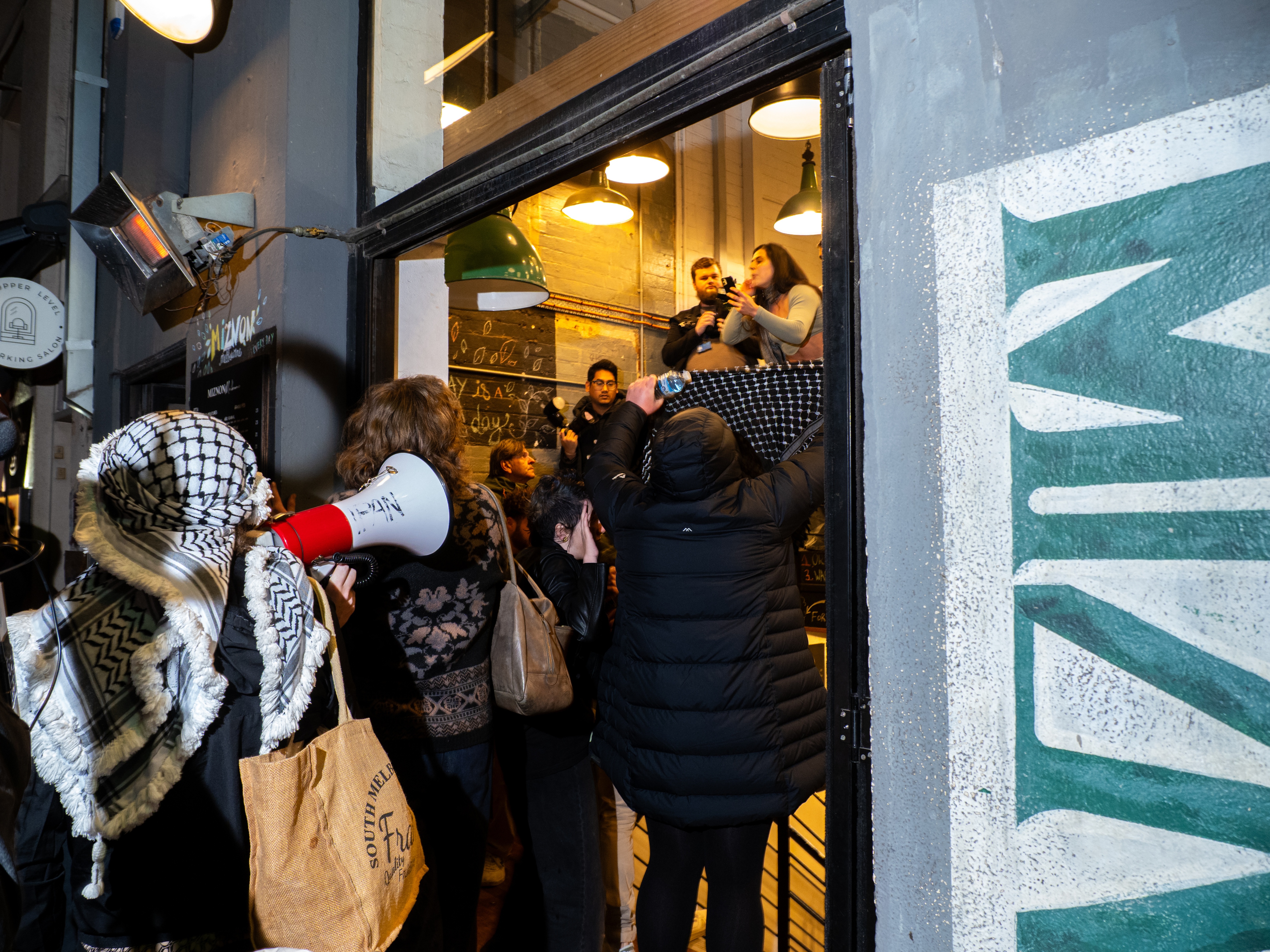 Protesters enter Miznon Hardware Lane in Melbourne, Australia, July 4. Demonstrators clashed with staff at the restaurant, which is co-owned by Shahar Segal, who had joined the Israeli- and U.S.-backed Gaza Humanitarian Foundation as a spokesperson. Segal has since left his role with the controversial Gaza food distribution group.