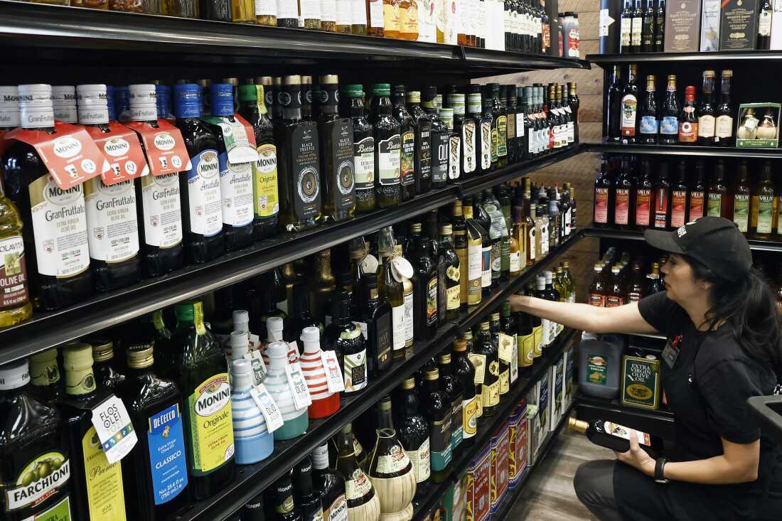 A worker restocks Italian olive oil at Claro's Italian Market in Arcadia, California.