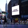 The Empire State Building is seen in the distance as people take photos of a giant screen showing the message "JUST&T MARRIED!" (T&T for Taylor and Travis) outside Madison Square Garden, where wedding celebrations of pop singer Taylor Swift and Travis Kelce of the Kansas City Chiefs were held, in New York City on Friday.
