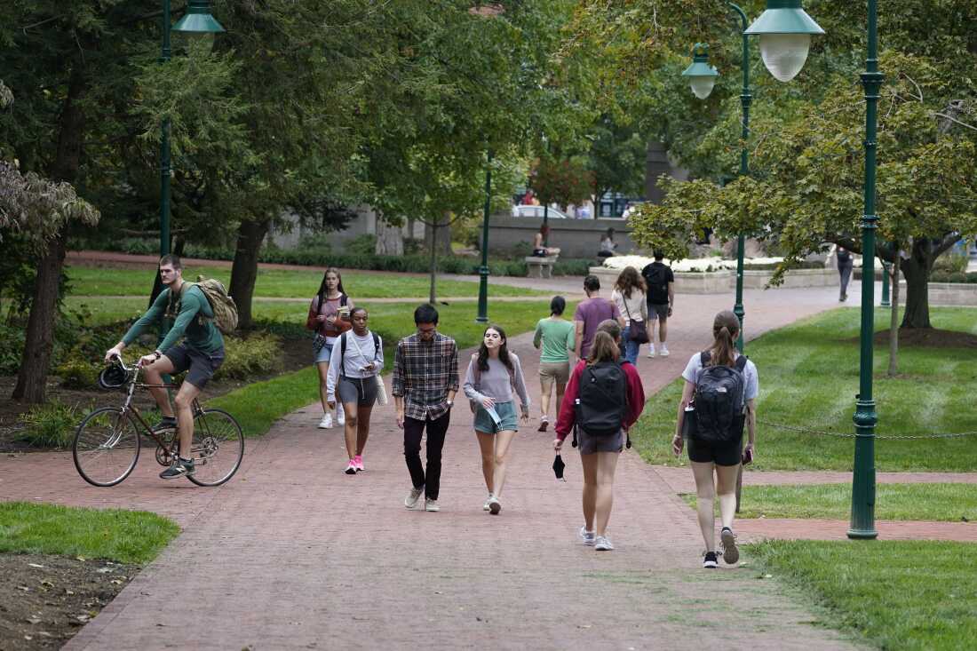 Students walk to and from classes on the Indiana University campus in Bloomington, Ind., in 2021.