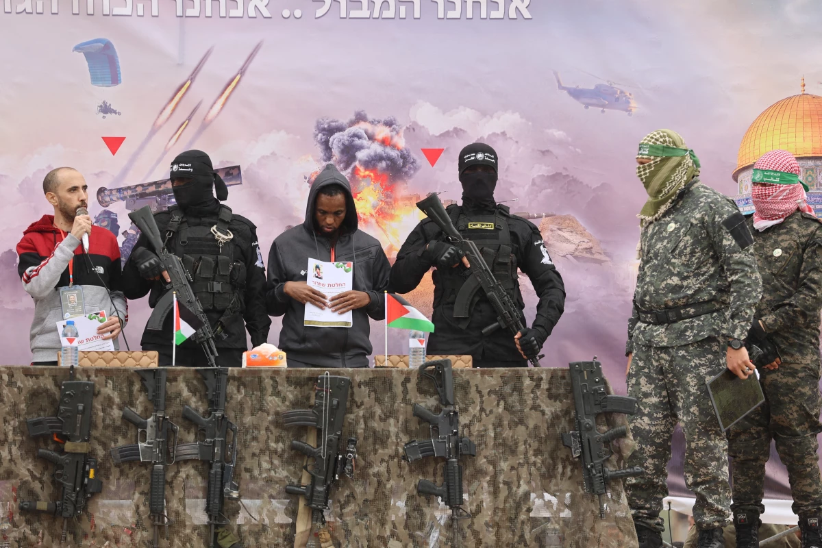 Israeli hostages Averu Mengistu (4th-R) and Tal Shoham (L) are flanked by Hamas fighters as they stand on a stage during their release in Rafah in the southern Gaza Strip on Saturday.