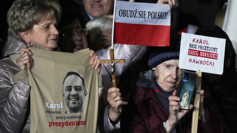 Supporters of conservative presidential candidate Karol Nawrocki hold up signs as they rally in Warsaw, Poland, Tuesday, May 13, 2025. The writing reads: Karol, the man who will become president, Wake up, Poland! and Our president Karol Nawrocki.