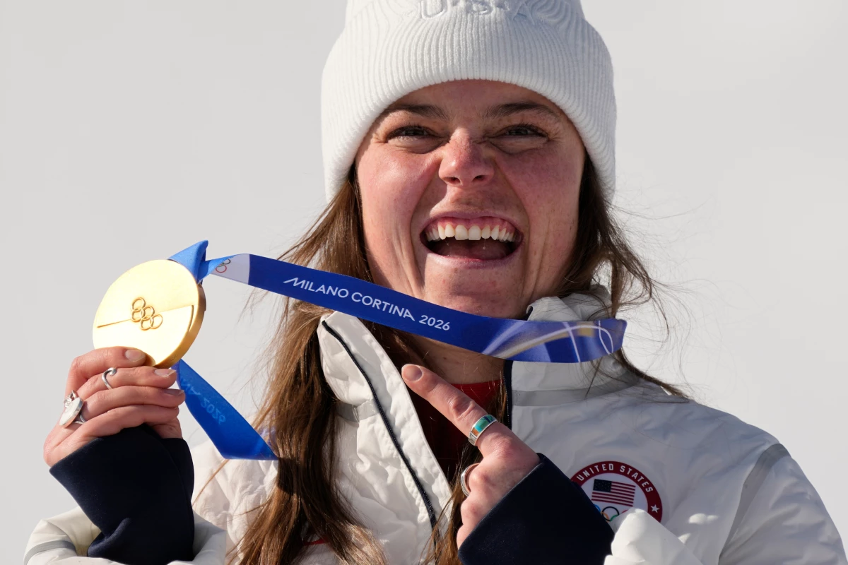 United States' Breezy Johnson shows her gold medal in the alpine ski women's downhill race, at the 2026 Winter Olympics, in Cortina d'Ampezzo, Italy, Sunday, Feb. 8, 2026.