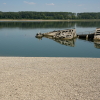 A man walks on the sandbank by the wreckage of a WWII German warship, emerged due to the drought, in front of Djerdap II, a large dam on the Danube River, between Romania and Serbia, near Prahovo, Serbia, Tuesday, Aug. 4, 2026.