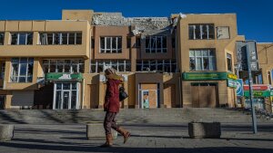 Woman walking in front of damaged building in Kherson on Jan. 4.
