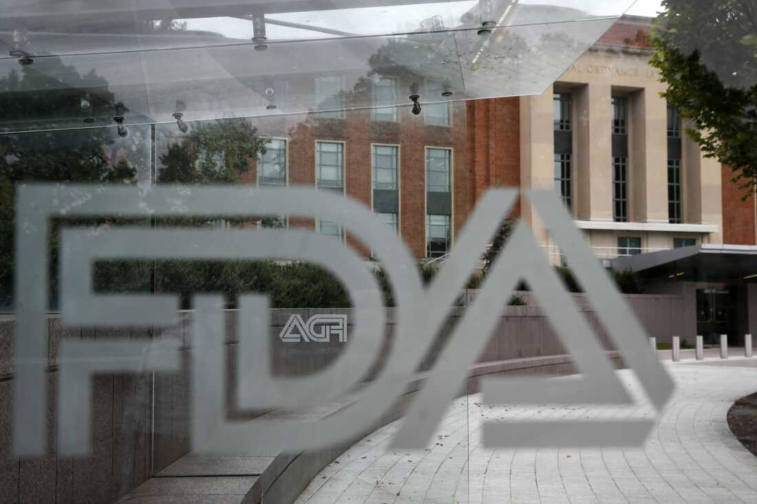 A U.S. Food and Drug Administration building is seen behind FDA logos at a bus stop on the agency's campus in Silver Spring, Md., in 2018.