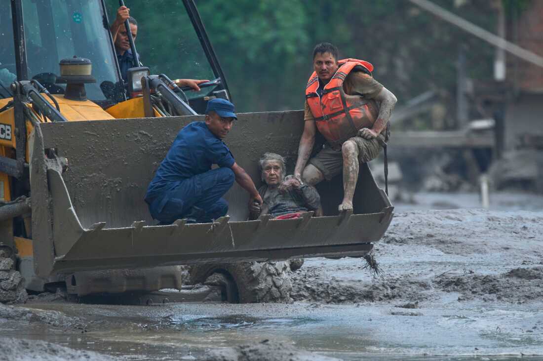 Kurtarma ekipleri, Nepal'in Nuwakot bölgesindeki Trishuli Nehri'nde meydana gelen ani sel felaketinde bir kurbanı güvenli bir yere taşımak için bir iş makinesi kullanıyor, Çarşamba, 26 Ağustos 2026.