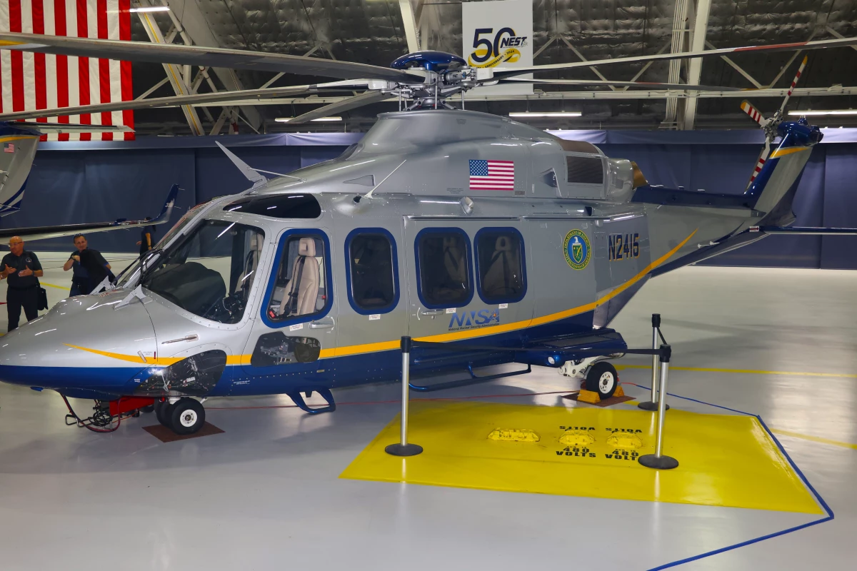 A NEST AgustaWestland 139 helicopter equipped with special radiation monitoring equipment on display during the team's 50th anniversary celebration at Joint Base Andrews. The helicopters, which measure radiation by flying low and slowly,  are deliberately painted with a civilian color scheme to avoid the 'black helicopter' stereotype.