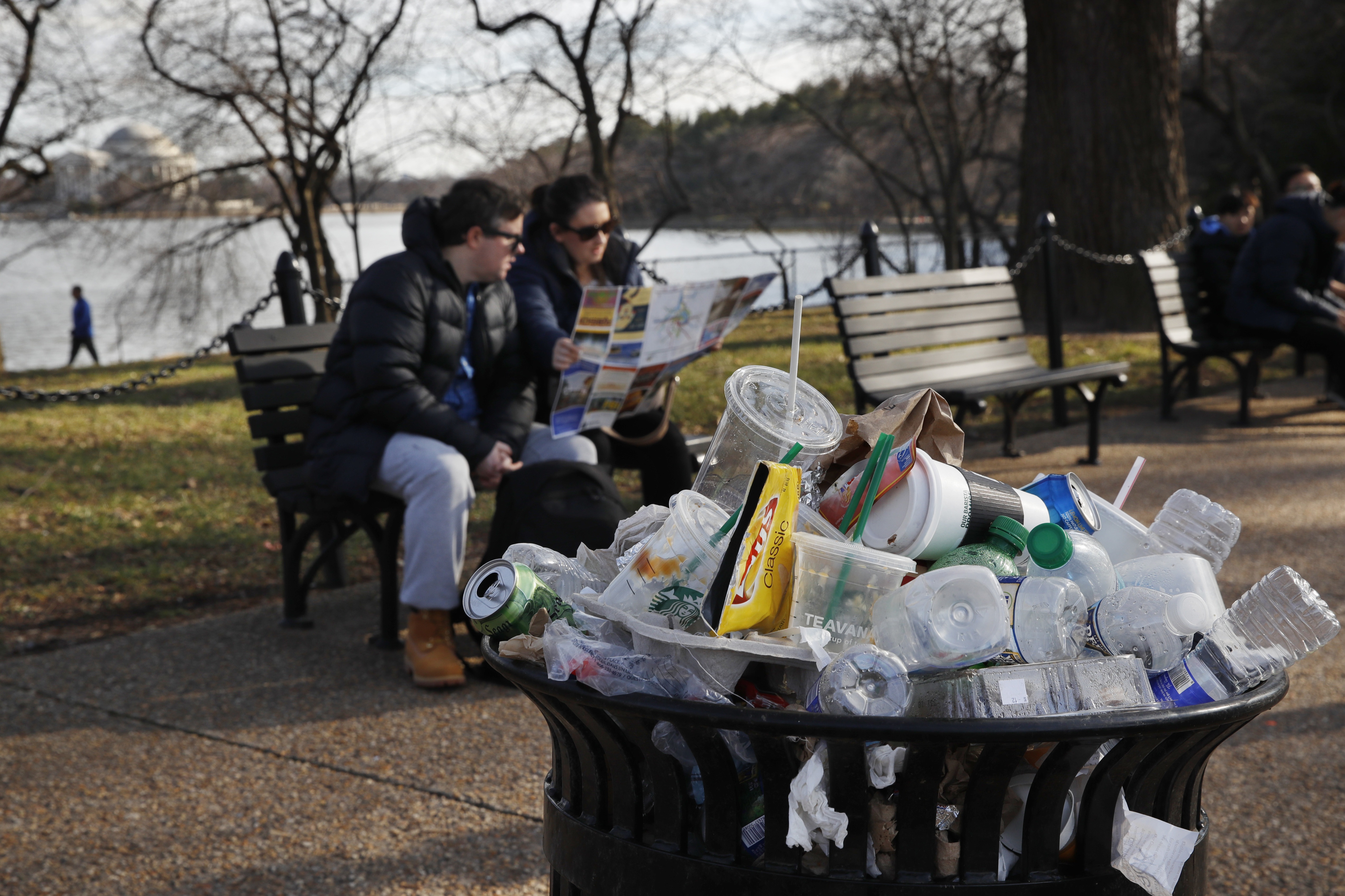 A trash can overflows as people sit outside of the Martin Luther King Jr. Memorial in Washington, D.C. (AP)