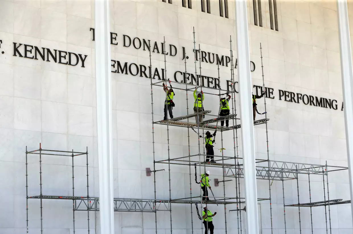 Workers construct scaffolding below the John F. Kennedy Center for the Performing Arts sign on Friday in Washington.