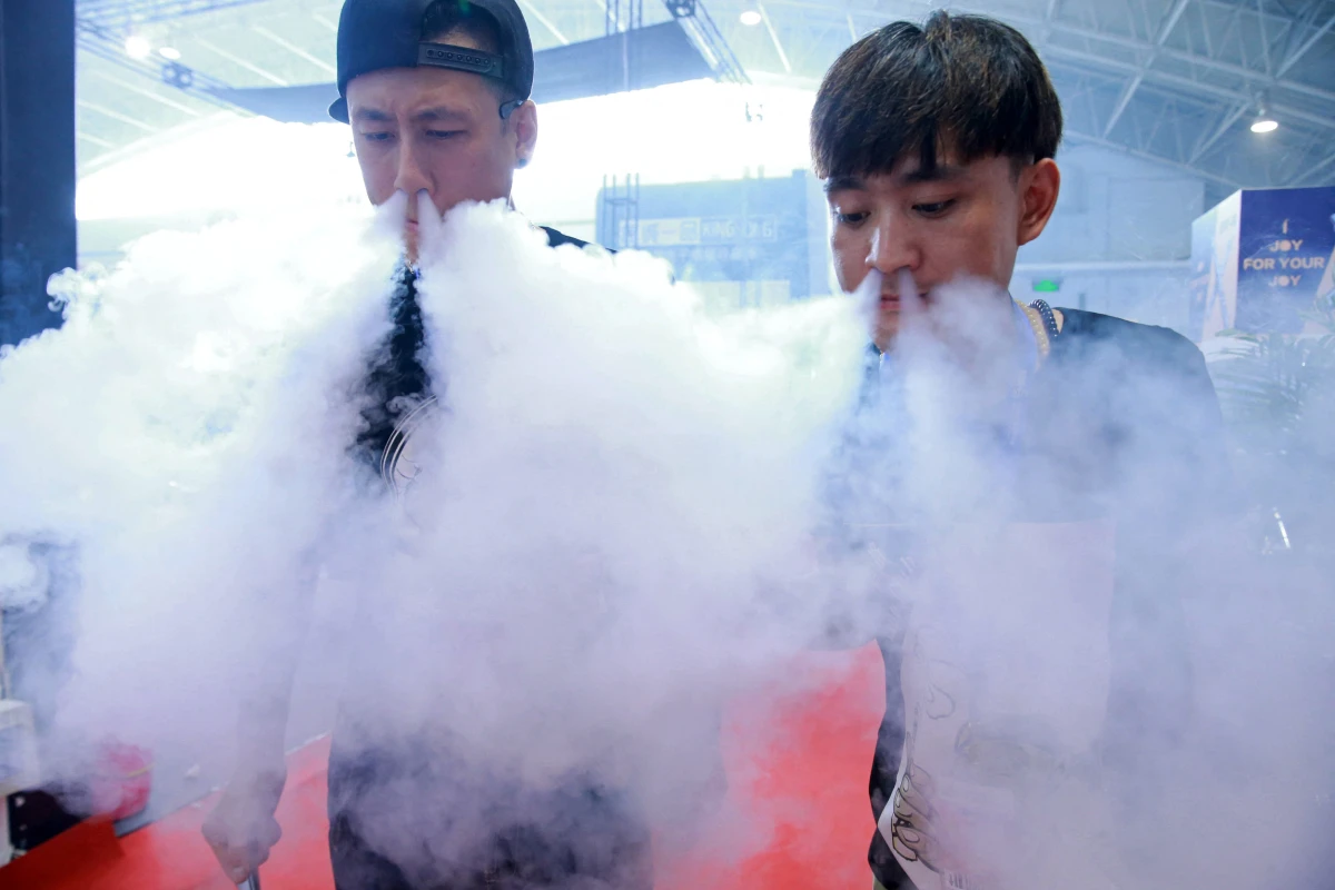 Sales staff demonstrate vaping at a vape expo in Beijing, China.