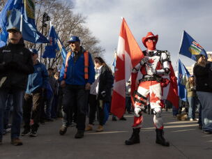 People cheer and wave flags at a rally hosted by Forever Canadian on Canadian Unity at the Edmonton Expo Center in Edmonton, Alberta, Canada on Oct.16, 2026.