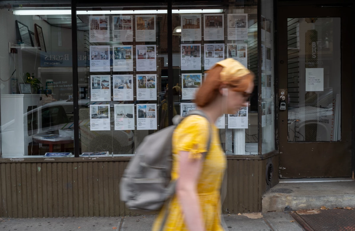 Ads for rental apartments are posted on the window of a real estate agent's office in Brooklyn, N.Y., during the summer of 2022.