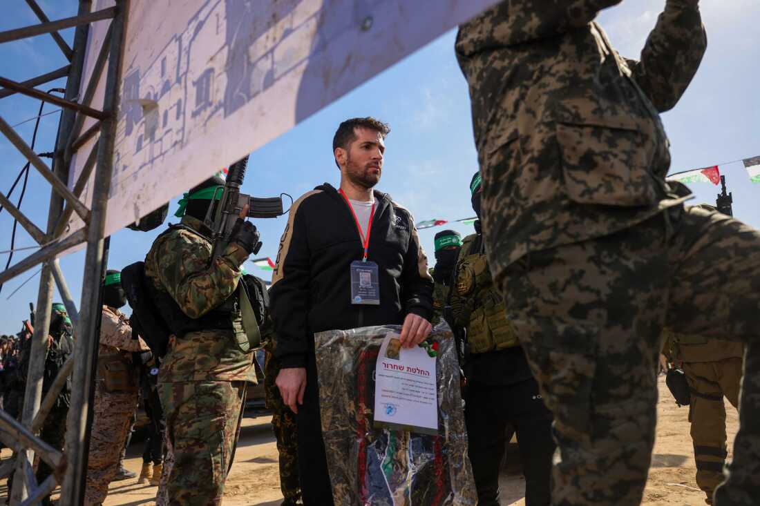 Hamas militants escort Israeli-American hotsage Sagui Dekel-Chen on a stage before handing him over to a Red Cross team in Khan Yunis, southern Gaza Strip, on February 15, 2025, as part of the sixth hostage-prisoner exchange.