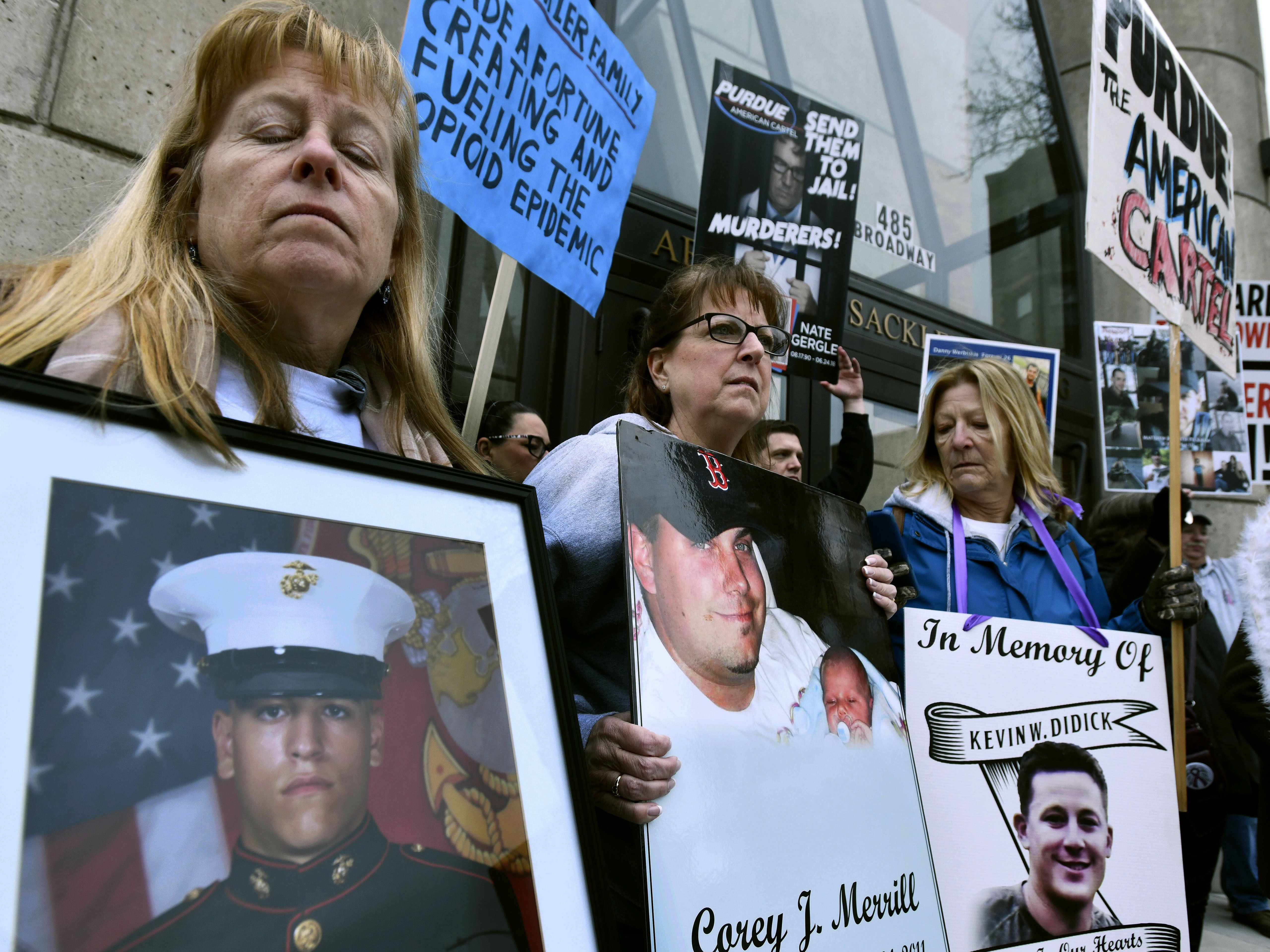 Kathleen Scarpone, left, of Kingston, N.H., and Cheryl Juaire, second from left, of Marlborough, Mass., protest in front of the Arthur M. Sackler Museum, at Harvard University, April 12, 2019, in Cambridge, Mass. Scarpone, who lost her son to OxyContin addiction, and Juarie addressed three Sackler family members during a virtual U.S. Bankruptcy Court hearing, Thursday, March 10, 2022.