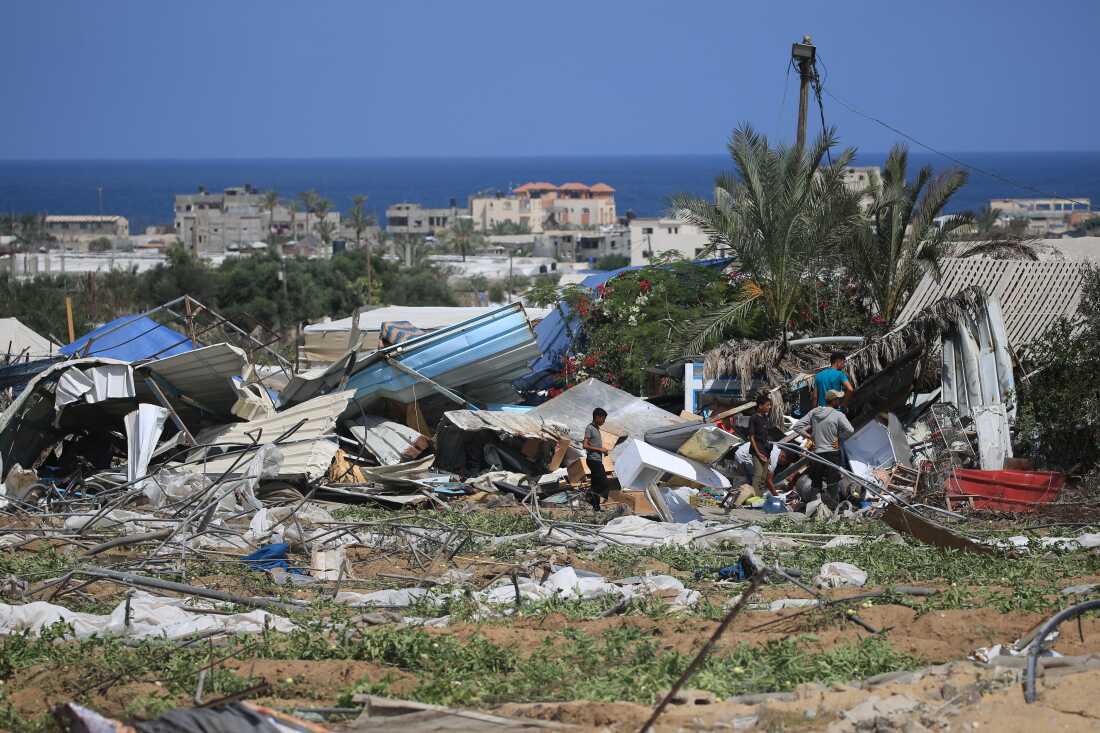 People look for salvageable items following an Israeli raid in al-Mawasi area in Rafah, on the southern Gaza Strip, on June 29.