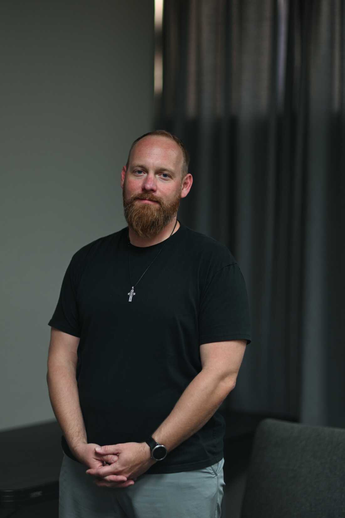 This photo is a portrait of Caleb Campbell at Desert Springs Bible Church in Phoenix. He is wearing a necklace with a silver cross pendant and a black T-shirt.