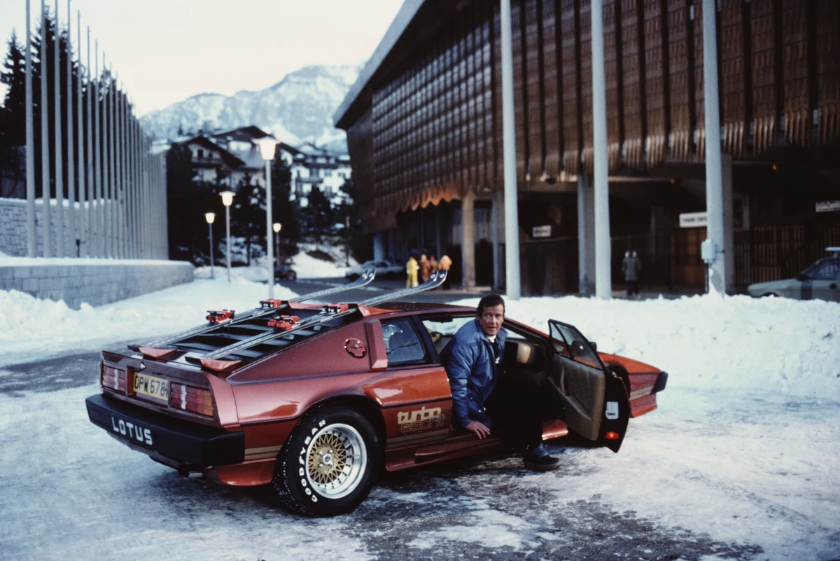 English actor Roger Moore poses as 007, with a Lotus Esprit Turbo, on the set of the James Bond film For Your Eyes Only in Cortina d'Ampezzo, Italy, in March 1981.