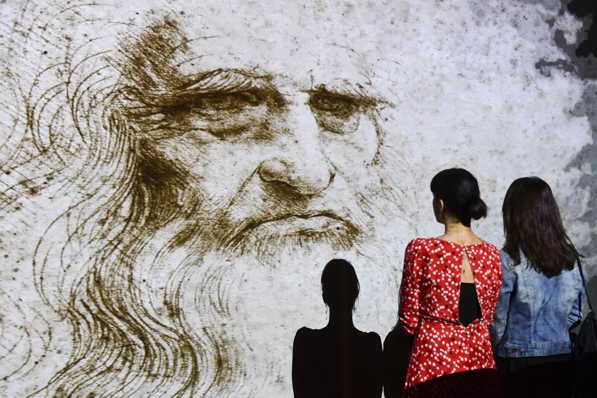 People watch a hologram called 'Studio di uomo barbuto' (study of bearded man) during a Leonardo da Vinci multimedia installation in Milan in 2019.